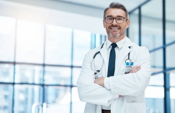 medic Doctor, man and happy with arms crossed in hospital for medical, career and happiness for portrait. Medic, smile and work in clinic for healthcare, wellness and health of community in Washington DC